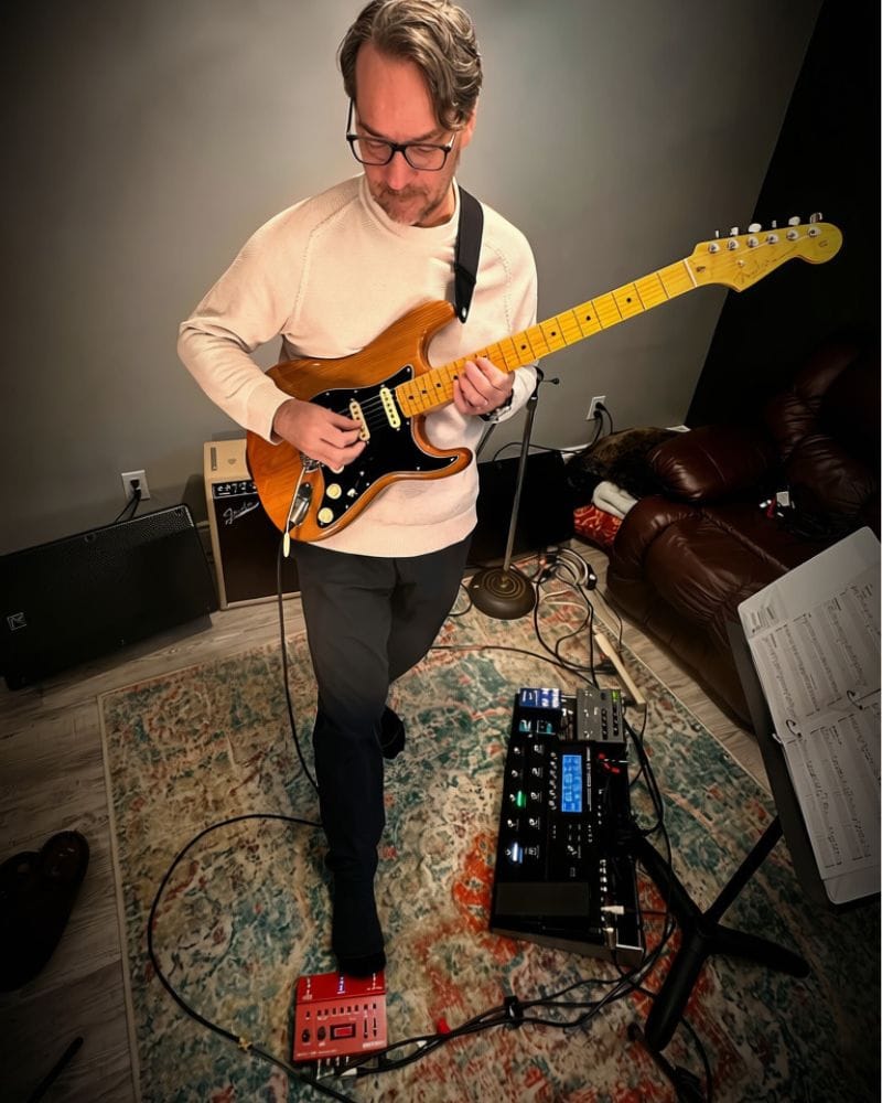 Brent Robitaille playing electric guitar with a looper pedal setup